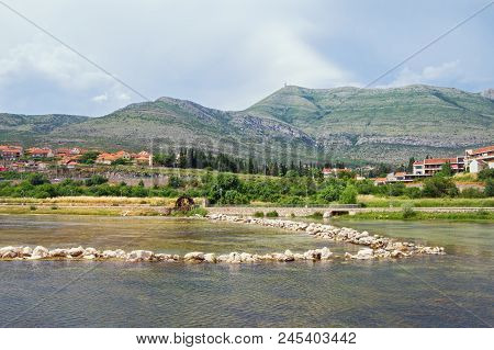 River Bank With Small Dam And Water Wheel. Bosnia And Herzegovina, View Of Trebisnjica River Near Tr
