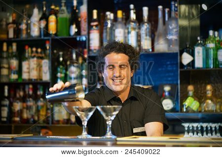 Professional Barman Man Pours A Fresh Cocktail To The Customers Of The Hotel Bar. The Concept Of Ser