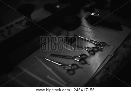 The Tools Of A Barber On The Desktop In Front Of The Mirror .black And White Photo Of Hairdresser To