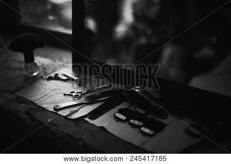 The Tools Of A Barber On The Desktop In Front Of The Mirror .black And White Photo Of Hairdresser To