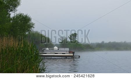 Pontoon Boat On Lift On Foggy Lake Irving In Bemidji Minnesota