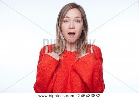 Headshot Of Young Woman In Red Holding Hands On Breast, Verbally Defending Herself, Having Perplexed