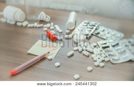 The Inscription On The Sticker - Sorry - Amongst The Scattered Pills On The Table.