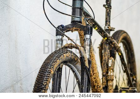 Dirty Mountain Bike Suspension Fork After Riding In Bad Weather. Dirt And Oil Stains On The Legs Of 