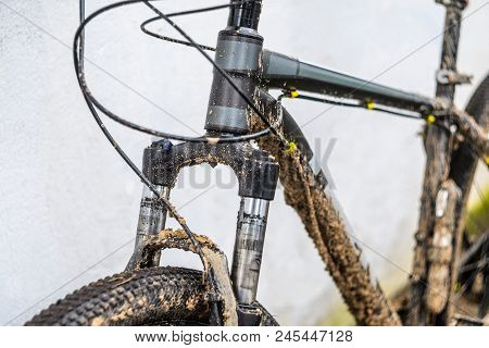 Dirty Mountain Bike Suspension Fork After Riding In Bad Weather. Dirt And Oil Stains On The Legs Of 