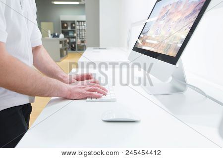 Hands Of A Man Close-up On A Mouse And A Computer Keyboard In A Technology Store. The Buyer Uses A C