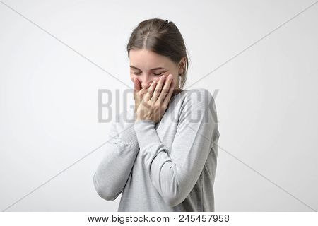 Pretty Caucasian Girl In Simple Pulover Is Shy To Hear A Compliment. She Is Hiding Her Face.