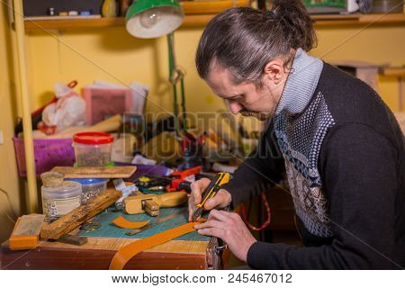 Professional Male Skinner, Tanner Working With Genuine Leather Belt At Workshop, Studio. Handmade An