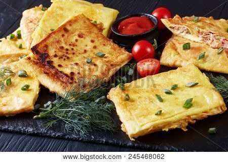 Msemen Stuffed With Pulled Chicken Meat And Vegetables On A Black Slate Plate With Tomato Sauce, Mor