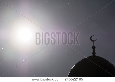 The Bright Sun And The Washed Out Silhouette Of The Minaret Of The Moslem Mosque. In The Sky Flies D