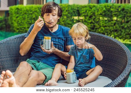 Father And Son Eat Dessert With Chia Seeds And Mangoes By The Pool In The Morning. Healthy Eating, V