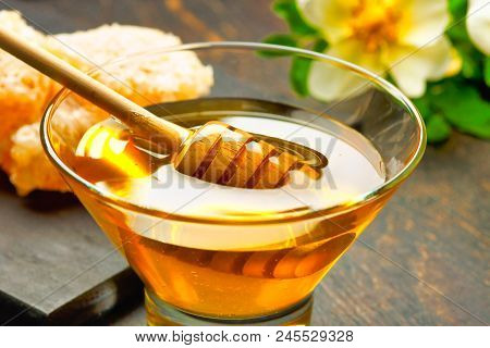 Honey With Wooden Honey Dipper On Wooden Table