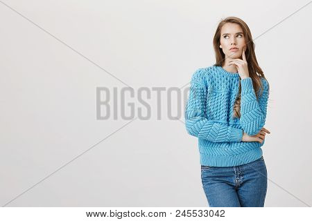 Stylish Attractive Woman In Trendy Sweater Holding Head On Hand While Looking Aside Thinking About S