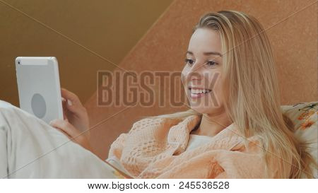 Smiling Woman Using Digital Tablet While Lying In Hospital Bed