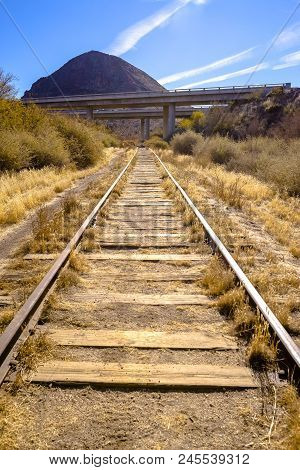 Train Tracks In The Desert With Dry Vegetaion Growing Between The Tracks. A Sunny Day In Jacumba, Ca