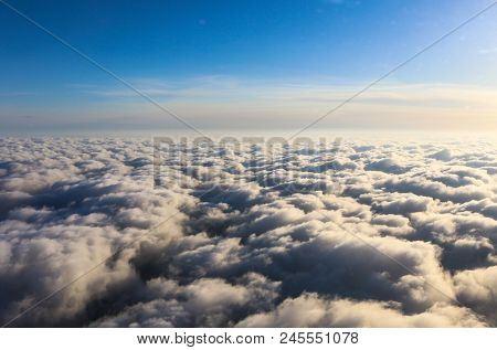 Sun Reflects Off Of Puffy Clouds As An Airplane Descends For Landing Into Airport - Point Of View Fr