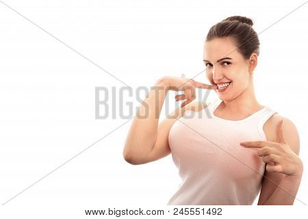 Young Woman Shows Her Big Fake Breasts On White Background With Copy Space