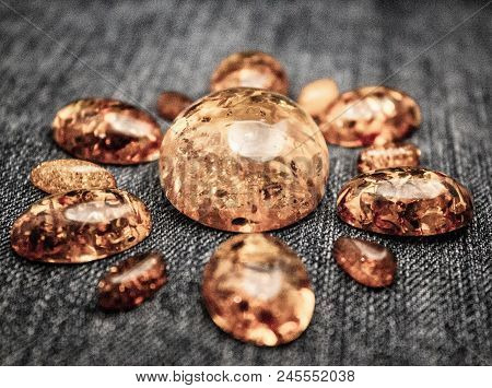 Artificial Amber Cabochons On A Black Background Macro