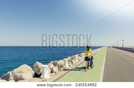 Mother Strolling With Newborn In A Coast Long Road. Vanishing Point Of View And Plenty Of Copy Space