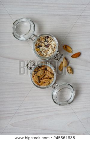 Still Life Of Healthy Food And Diet Food, Almonds And Muesli In Glass Jars On A Wooden Background.