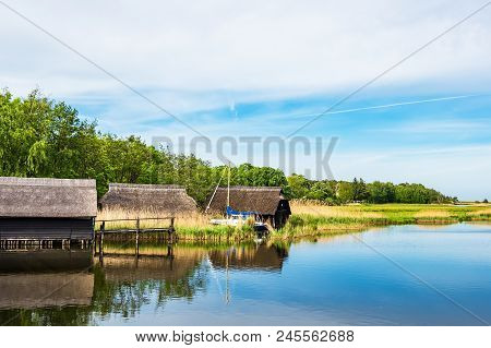 Lake With Reeds And Boathouses In Prerow, Germany.