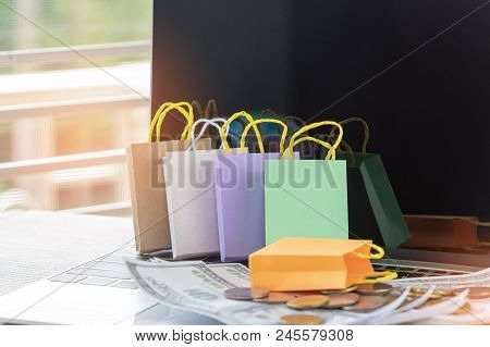 Close Up Of Colorful Shopping Bags And Money On Laptop Keyboard. Consumers Can Buy Products Directly