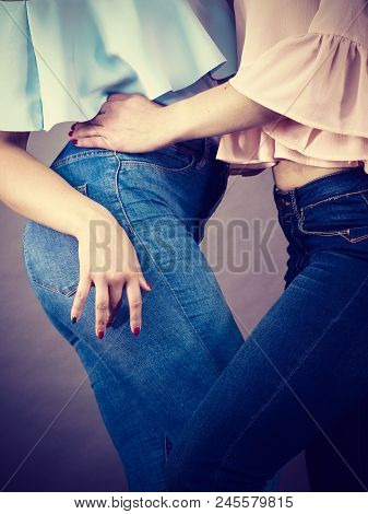 Two Unrecognizable Women Having Fashionable Outfits, Blue Jeans And Colorful Shirts. Fashion And Clo