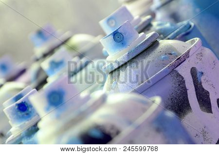 A Lot Of Dirty And Used Aerosol Cans Of Bright Blue Paint. Macro Photograph With Shallow Depth Of Fi