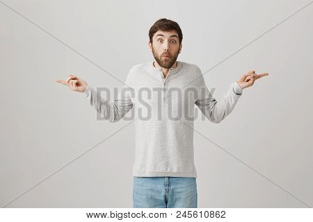 Man Tries To Look Uninvolved. Portrait Of Confused And Questioned Man With Beard Spreading Hands And