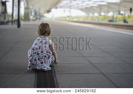 Little Girl Child In A Dress Playing With A Ball On A Deserted Railway Perron