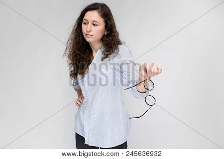 Happy Young Girl In A Light Blouse And Dark Pants. The Girl Refuses To Take Glasses.