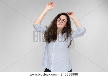 Happy Young Girl In A Light Blouse And Dark Pants. Girl Dancing.