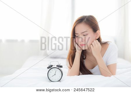 Beautiful Of Portrait Young Asian Woman Wake Up In Morning Annoyed Looking  Alarm Clock, Girl Lying 