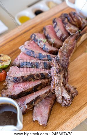Grilled tomahawk steak on wooden plate