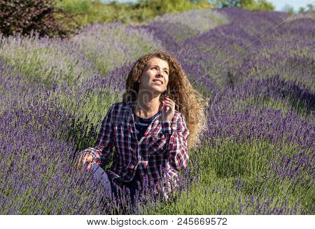 Ostrow, Poland - June 6, 2018: Beautiful  Woman With Long Curly Hair In The Middle Of A Lavender Fie