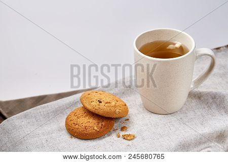 White Porcelain Mug Of Black Tea Or Earl Grey And Pile Of Sweet Cookies On Homespun Napkin Over Whit