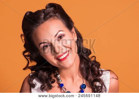 Beautiful Brunette With Hairdo And Make Up Smiles In Studio, Pin Up Style, Close Up Portrait