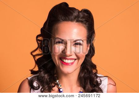 Happy Brunette With Hairdo And Make Up Smiles In Studio, Pin Up Style, Close Up Portrait