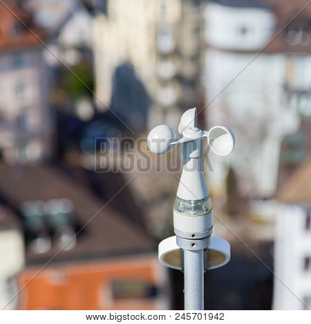White Anemometer Wind Gauge With Houses In Background