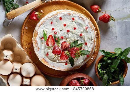 Strawberry Tart Covered With Whipped Sour Cream Surrounded By Organic Ingredients Over White Backgro
