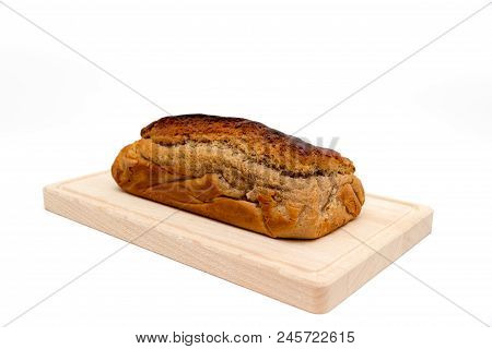 A Homemade Plumcake Standing On A Wooden Board With A White Background