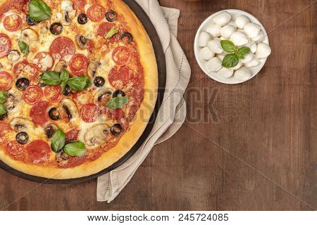 Overhead Photo Of Pepperoni Pizza With Mozzarellini Cheese, Shot From Above On Dark Rustic Backgroun