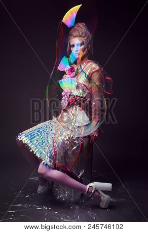 Gorgeous Woman In Biofuture Pompadour Style. Female In Fashion Transparent Raincoat With Splendid Ma