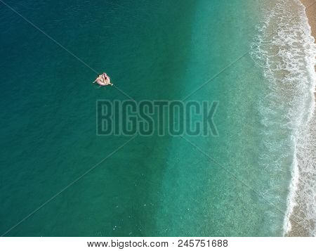 Aerial View Young Woman On Giant Inflated Flamingo Float In Turquois Water Of Ionian Sea Albania.