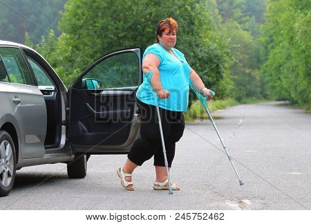 Disabled woman upgoing from a car. Transportation and travel for handicapped people.
