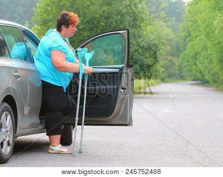 Disabled woman upgoing from a car. Transportation and travel for handicapped people.