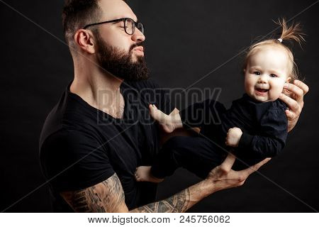 Adorable Cute Infant Girl With Joyful Face Expression Posing On Loving Father Hands Over Studio Blac