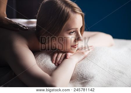 Close Up Profile Head Of Beautiful Young Caucasian Woman Getting Massage In Spa Over Dark Background