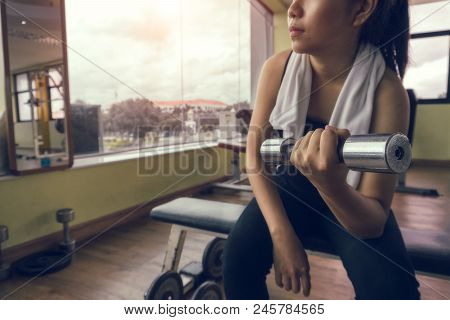 Close-up Of A Young Woman Exercising With Weights In The Gym. Fit Girl With Dumbbell. Sport And Fitn