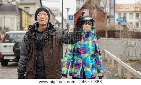 Asian Senior Couple Travel Walking In Rekjavik, Iceland Downtown